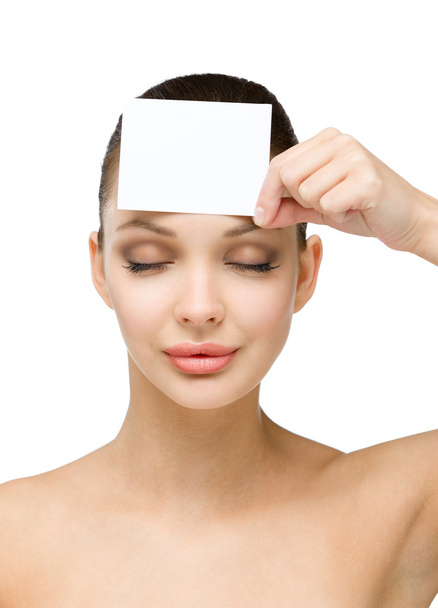 Sexy girl keeps copyspace card in front of her forehead - Zdjęcie, obraz