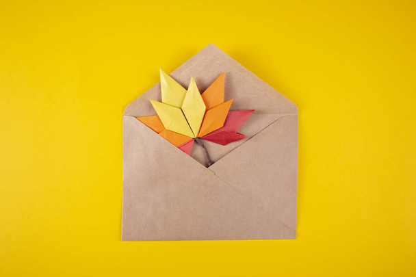 Papírové origami podzimním konceptem padlé listy dopis v obálce na žlutém pozadí řemeslné umělecké dílo - Fotografie, Obrázek