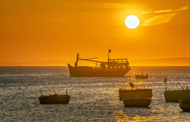 Морской пейзаж на закате, когда рыбацкие лодки в море, чтобы собрать рыбу в конце дня
. - Фото, изображение