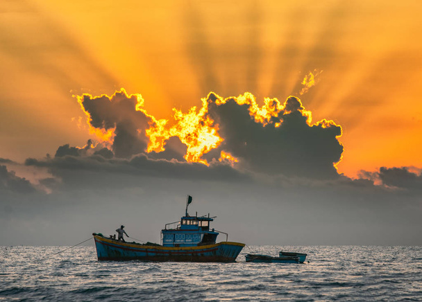 太陽が光る夜明けに海に出る漁船は、海でカラフルな歓迎の新しい日を歓迎します - 写真・画像
