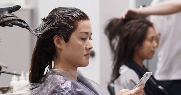 Dziewczyny chodzą razem do salonu fryzjerskiego, rozmawiają i leczą włosy - Zdjęcie, obraz