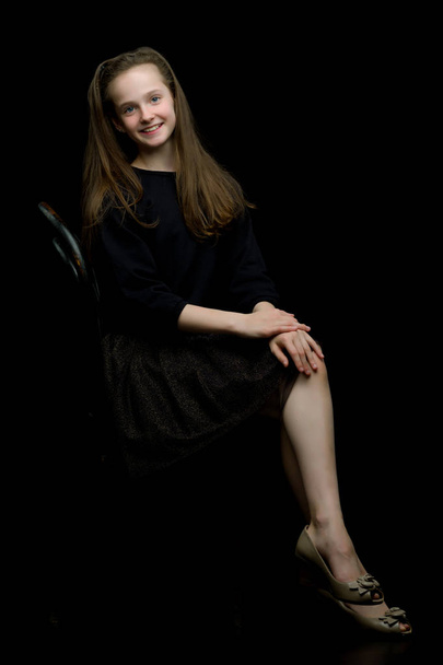 Portrait of a little girl sitting on an old Viennese chair, blac - Photo, Image