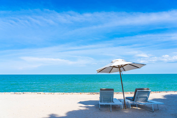 Hermoso paraguas y silla alrededor de la playa mar océano con azul sk
 - Foto, Imagen