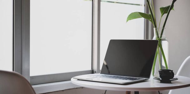 moderner Arbeitsplatz mit offenem Laptop, Kaffeetasse und Bürobedarf - Foto, Bild