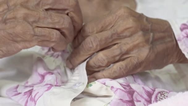 Oudere vrouw Bevestig knoppen op jurk, progressieve hersenstoornis, close-up hand - Video