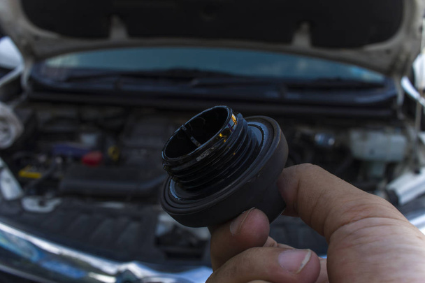 Auto mechanic checking engine oil dipstick in car with oil cap . - Photo, Image