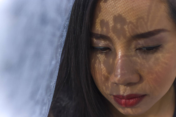 hübsches thailändisches junges Mädchen mit dramatischem Make-up im Freien mit Schatten - Foto, Bild