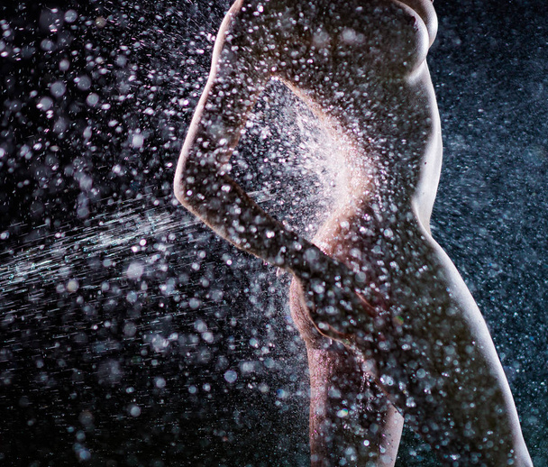 Beautiful, sporty, naked female body with lots of drops and splashes of water on a dark background. - Fotoğraf, Görsel
