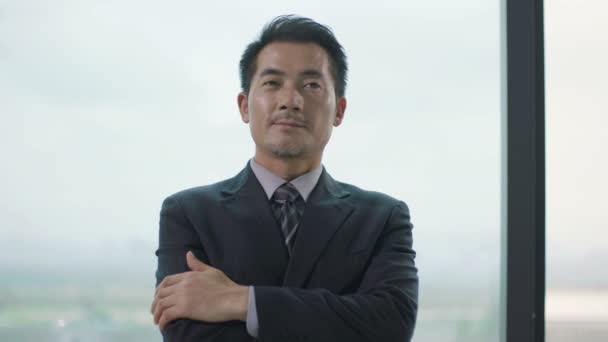 pensativo asiático corporativo ejecutivo de pie pensamiento por la ventana
 - Imágenes, Vídeo