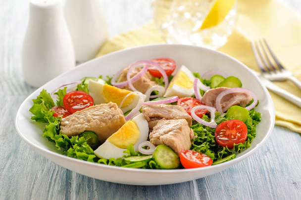 Verse groente salade met gekookte kip ei en vis. - Foto, afbeelding