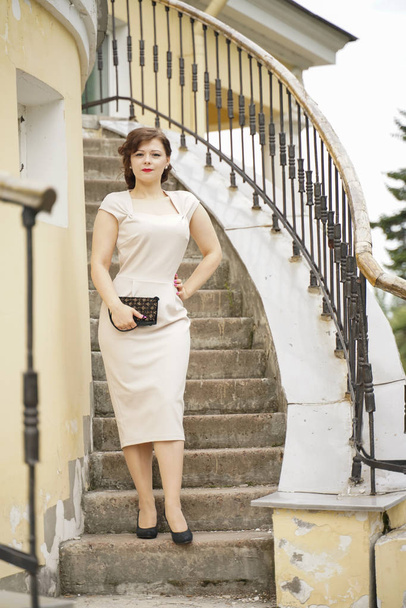 ritratto di moda di giovane donna in classico pinup abito beige all'aperto in città
 - Foto, immagini