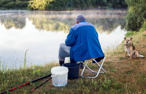 Человек рыбачит на берегу прекрасного озера
. - Фото, изображение