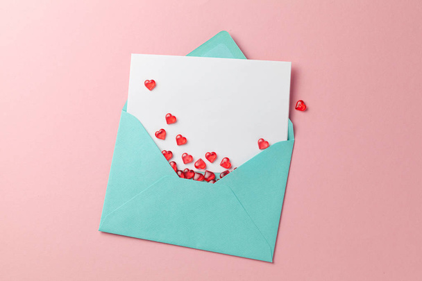Lettera d'amore con i cuori rossi. Modello in bianco con posto per testo su cartolina. Busta verde su sfondo rosa. mock-up
 - Foto, immagini