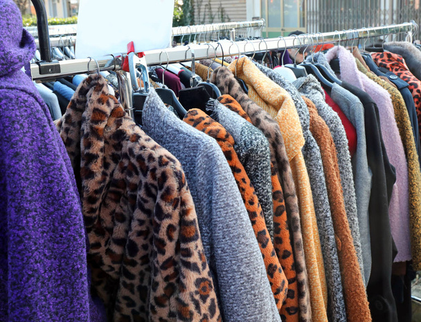 ρούχα και γούνες που κρέμονται στον πάγκο της αγοράς το χειμώνα - Φωτογραφία, εικόνα