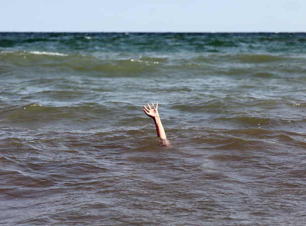 человек просит о помощи во время утопления в море
 - Фото, изображение