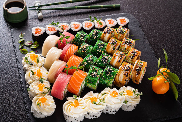sushi set on the black background, close up - Фото, изображение