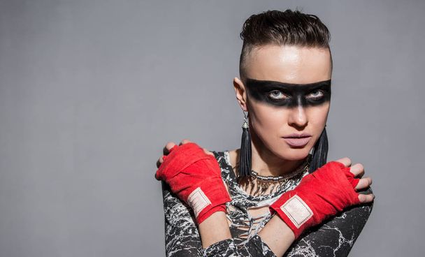 Beautiful woman with warrior makeup and boxing tape for punching - Foto, afbeelding