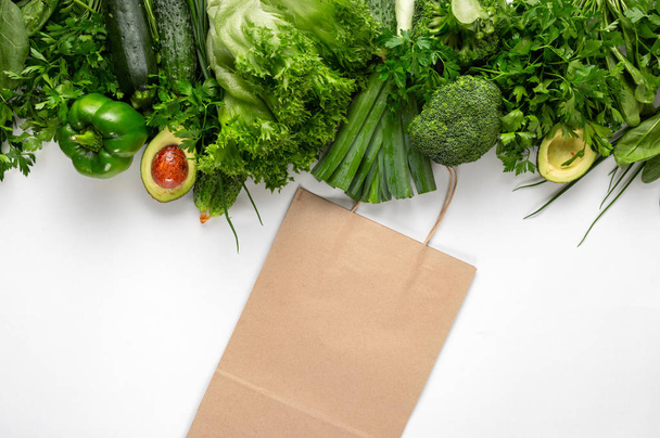 Paper bag with green vegetables. Purchase healthy vegan and vegetarian food - Fotó, kép