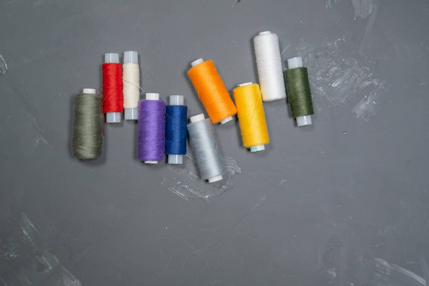Multi-colored threads on a gray background - Фото, изображение