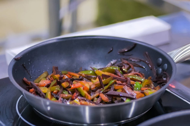 Pepper and beetroot frying and sizzling in pan - Photo, Image