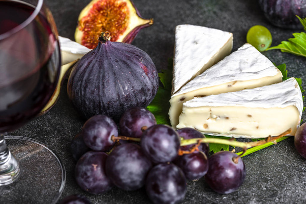 Fruit and wine snack. Camembert cheese, wine, grape and figs, closeup. - Foto, afbeelding
