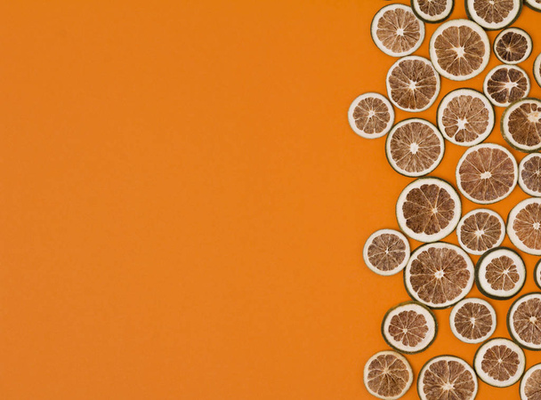 Сушені скибочки лайма на помаранчевому фоні
 - Фото, зображення