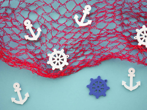 dekorativer blauer Hintergrund mit Fischernetz, Ankern und Lenkrädern - Foto, Bild