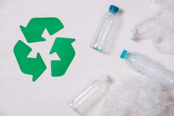 экологический символ утилизации отходов с вывозом мусора на каменный стол вид сверху
 - Фото, изображение
