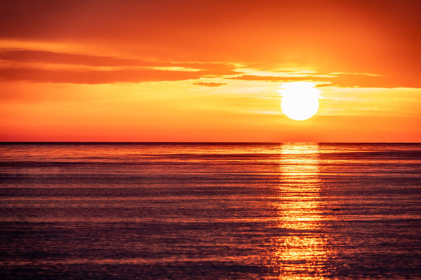 Belo pôr-do-sol vermelho e laranja sobre o mar. O sol põe-se sobre o mar
. - Foto, Imagem