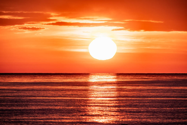 Prachtige rode en oranje zonsondergang over de zee. De zon ondergaat over de zee. - Foto, afbeelding