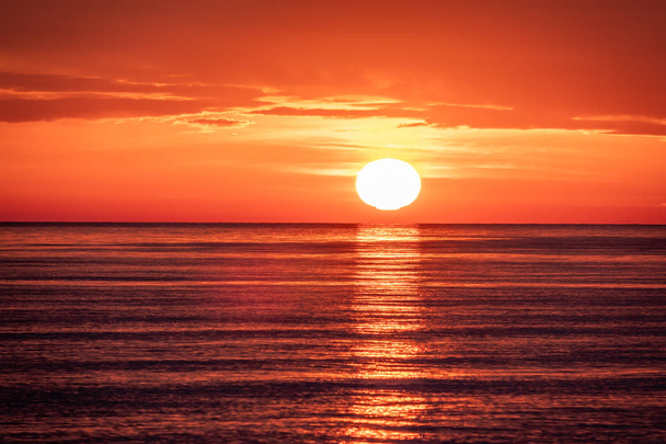 Beautiful red and orange sunset over the sea. The sun goes down over the sea. - Foto, imagen