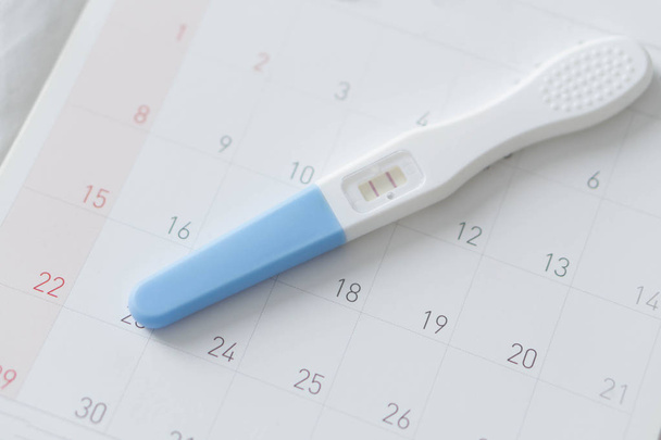 Тест на беременность на календарном фоне, концепция здравоохранения
 - Фото, изображение