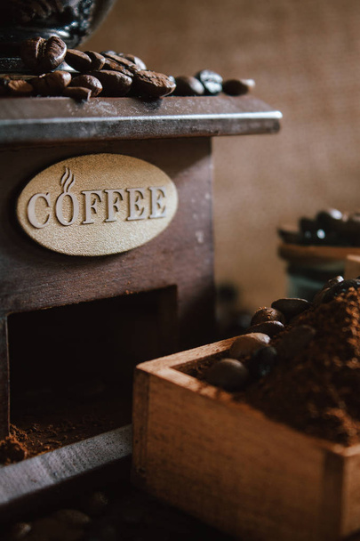 素朴な背景にコーヒー豆と古いコーヒーミルとの静物 - 写真・画像