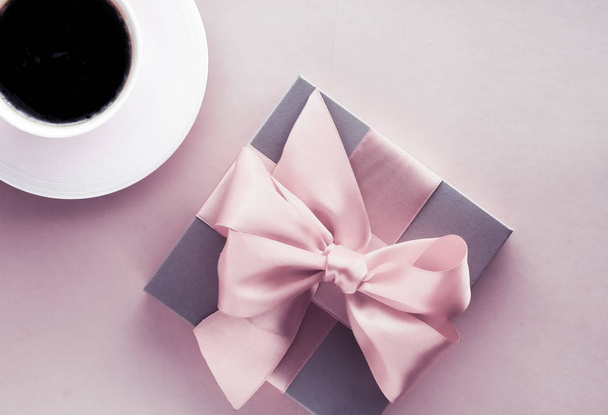 Caixa de presente de luxo e xícara de café no fundo rosa blush, flatlay
 - Foto, Imagem