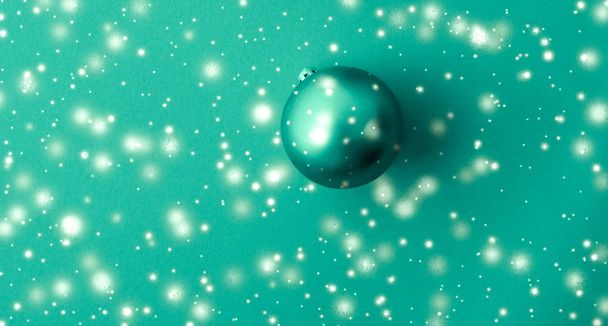 Bola de Navidad sobre fondo verde con brillo de nieve, lujo
  - Foto, imagen