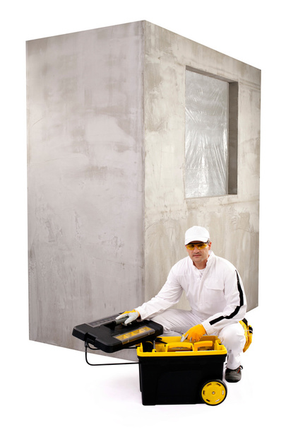 Trabajador de la construcción con caja de herramientas abierta y pared de cemento en blanco b
 - Foto, imagen