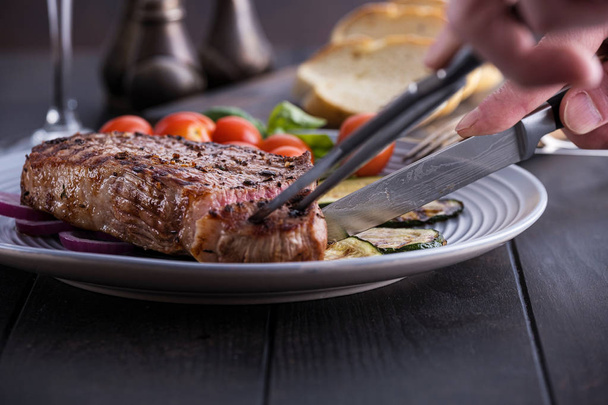 Mann schneidet Steak aus Rindfleisch - Foto, Bild