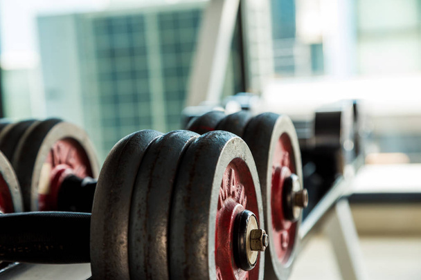 Iron dumbbell on shelf in fitness gym - Photo, Image