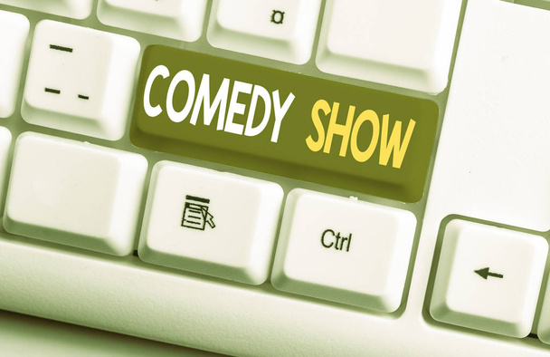 Conceptual hand writing showing Comedy Show. Business photo text Funny program Humorous Amusing medium of Entertainment White pc keyboard with note paper above the white background. - Photo, Image