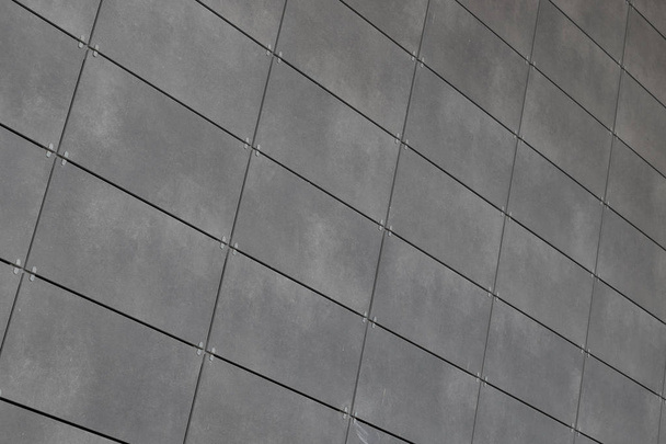 Γωνιακή θέα της σύγχρονης μόλις τοποθετηθεί γκρι κεραμικά πλακάκια με σκούρο κοινό. Φόντο, υφή ή μοτίβο για το σχεδιασμό. - Φωτογραφία, εικόνα