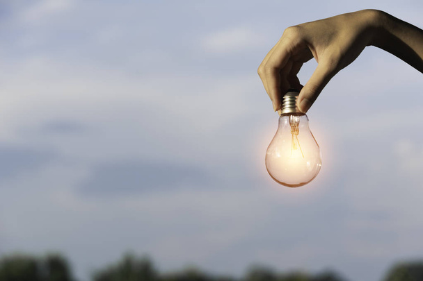 Innovation et énergie concept de main tenir une ampoule et copier
 - Photo, image