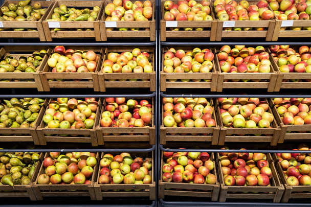 Supermarket laskuri paljon puulaatikoita tuoreita omenoita ja päärynöitä
 - Valokuva, kuva