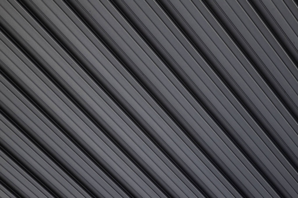 Diagonale weergave bij grijs metaal reliëf bouwoppervlak op de achtergrond. - Foto, afbeelding