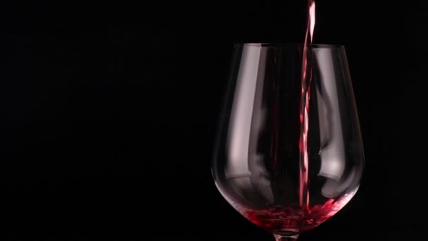 Rode wijn gieten in glas in een bar. Rode wijn op zwarte achtergrond gieten. - Video