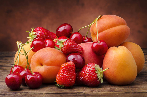 seizoensfruit met rode en oranje vruchten - Foto, afbeelding
