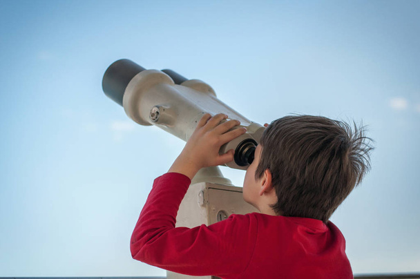 le garçon regarde le télescope touristique sur
 - Photo, image