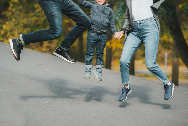 Joyful happy family jump on country road in autumn. Closeup. - Photo, Image