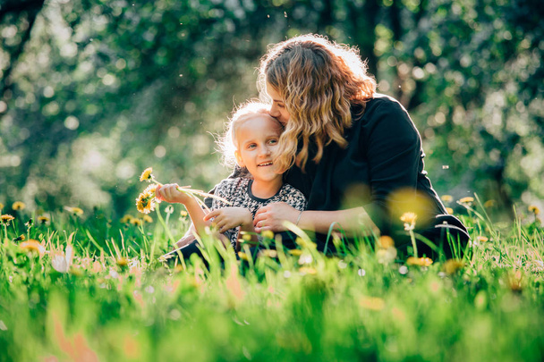 Mother and daughter having fun in the park. Happiness and harmony in family life.  Beauty nature scene with family outdoor lifestyle. Woman and cheerful little girl - Foto, afbeelding