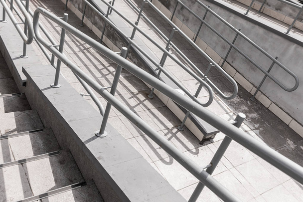 Γκρι ανοξείδωτο κιγκλιδώματα για άτομα με ειδικές ανάγκες σε σκυρόδεμα σκάλες φόντο - Φωτογραφία, εικόνα