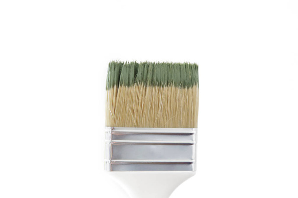 Immagine ravvicinata di un pennello immerso nel colore della vernice verde isolato su bianco
 - Foto, immagini